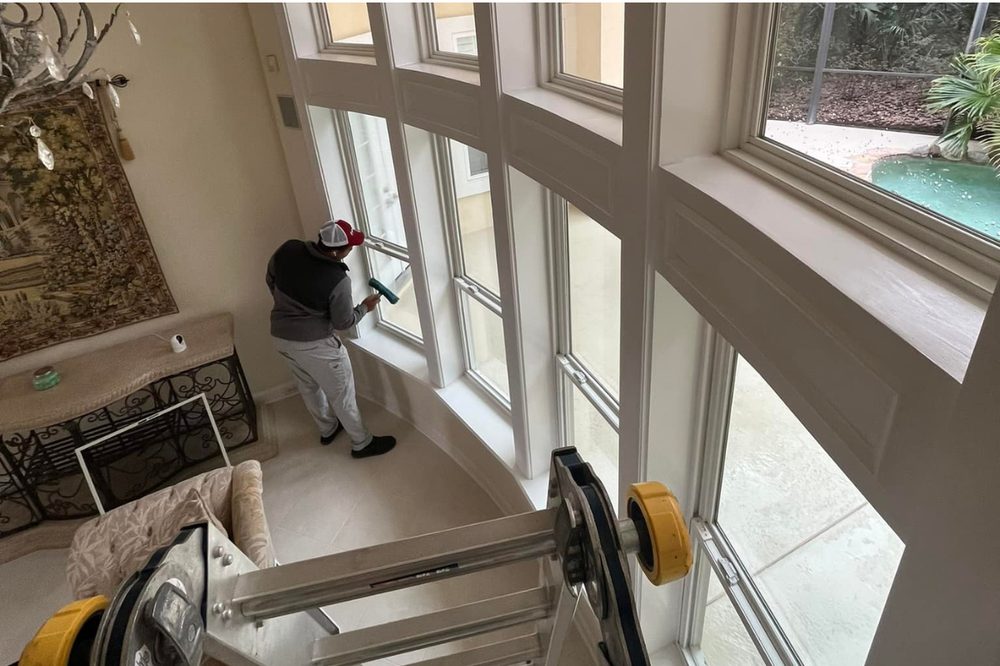 Technician cleaning interior windows in a Jacksonville home